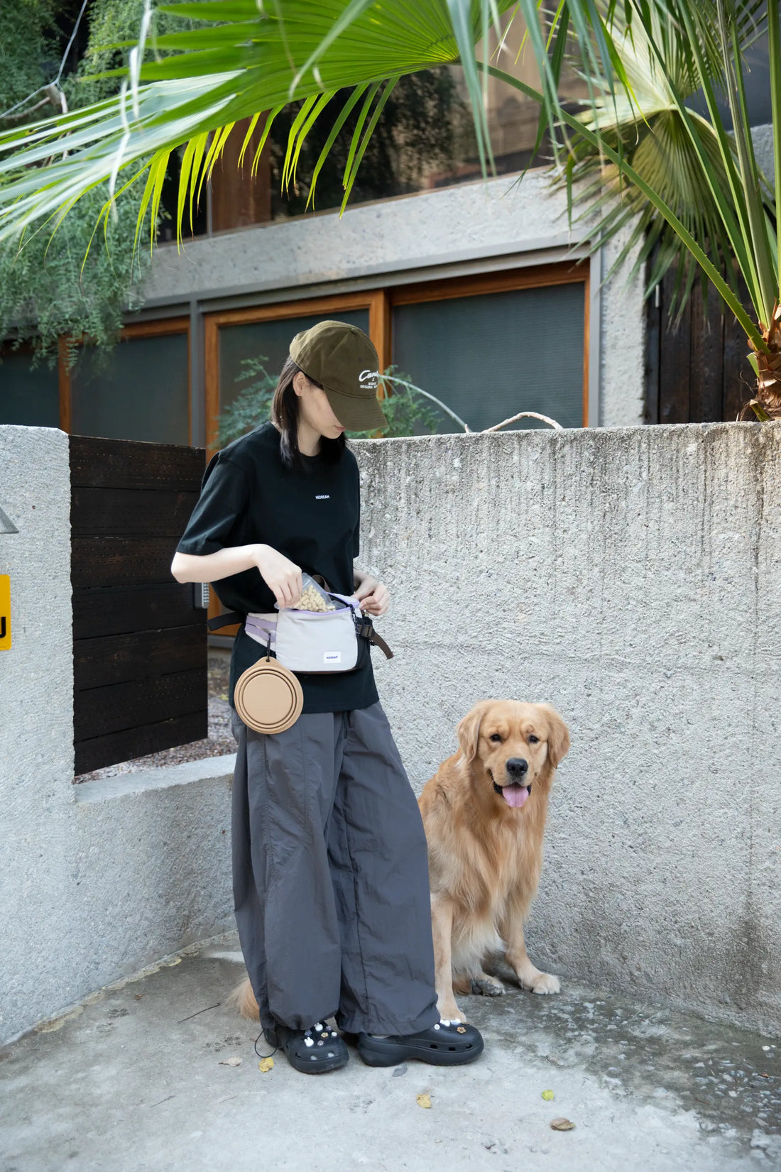 Dog trainer wearing a HiDREAM treat pouch beside a Golden Retriever