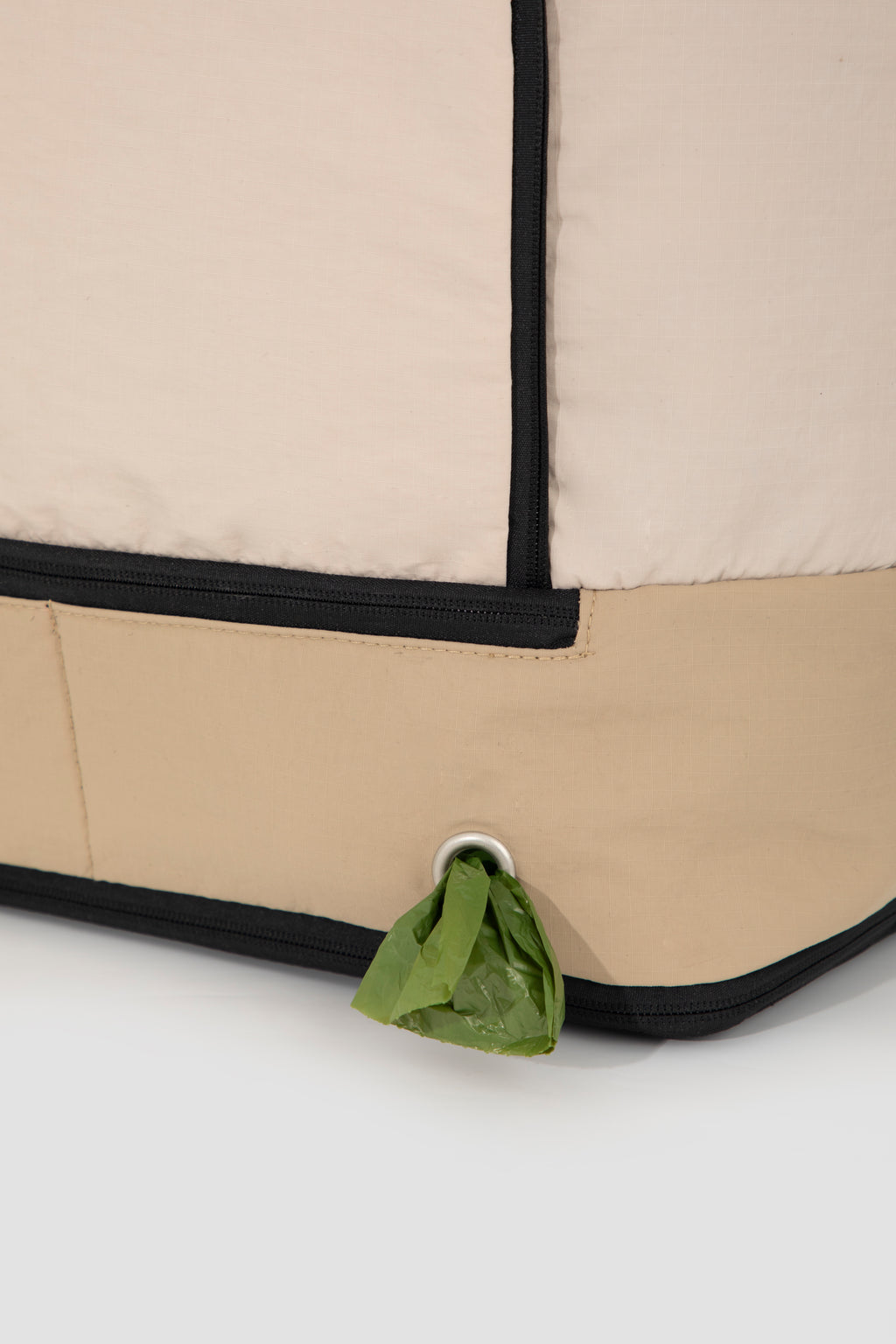 Close-up of poop bag dispenser on beige HiDREAM Crossbody Travel Bag for Pets, integrated for convenience during outings.