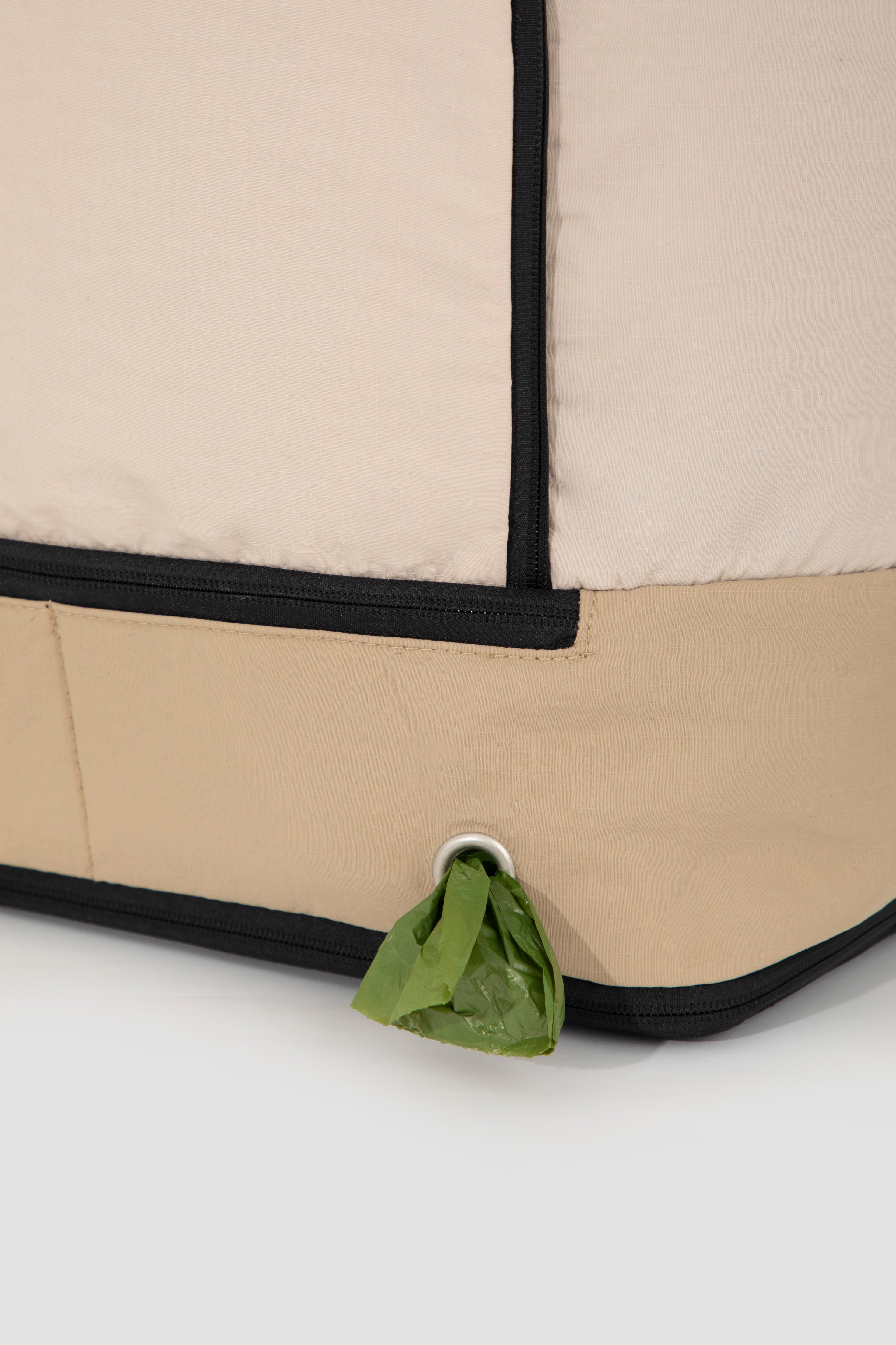 Close-up of poop bag dispenser on beige HiDREAM Crossbody Travel Bag for Pets, integrated for convenience during outings.