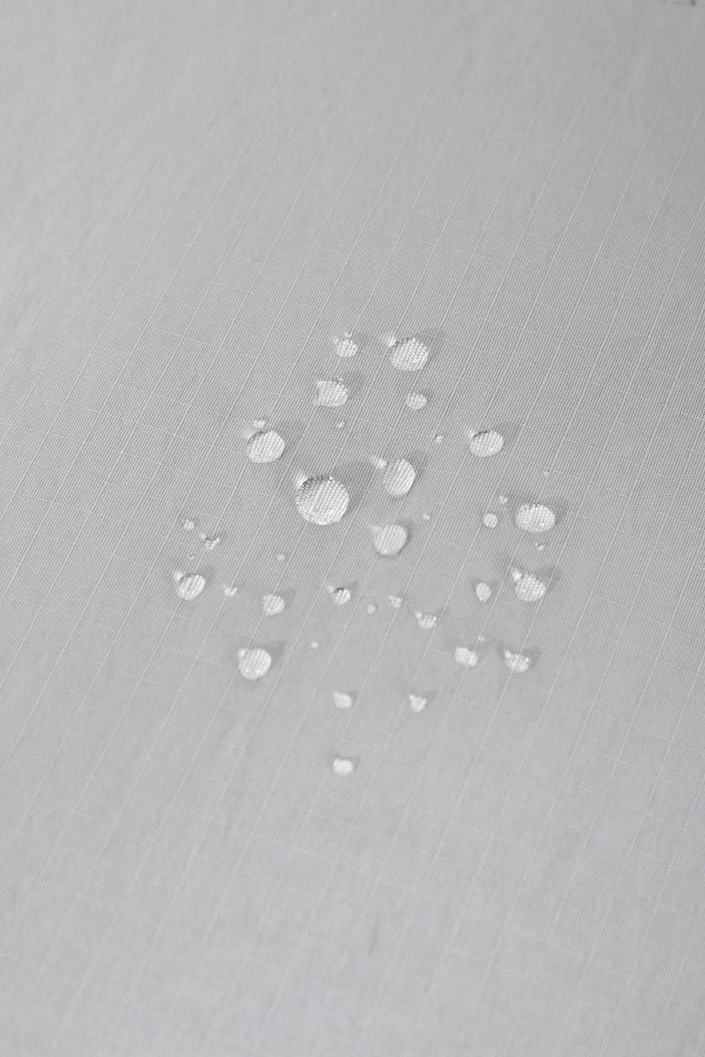 Water droplets on waterproof fabric of HiDREAM Crossbody Pet Carrier Tote. Durable and weather-resistant for outdoor use.