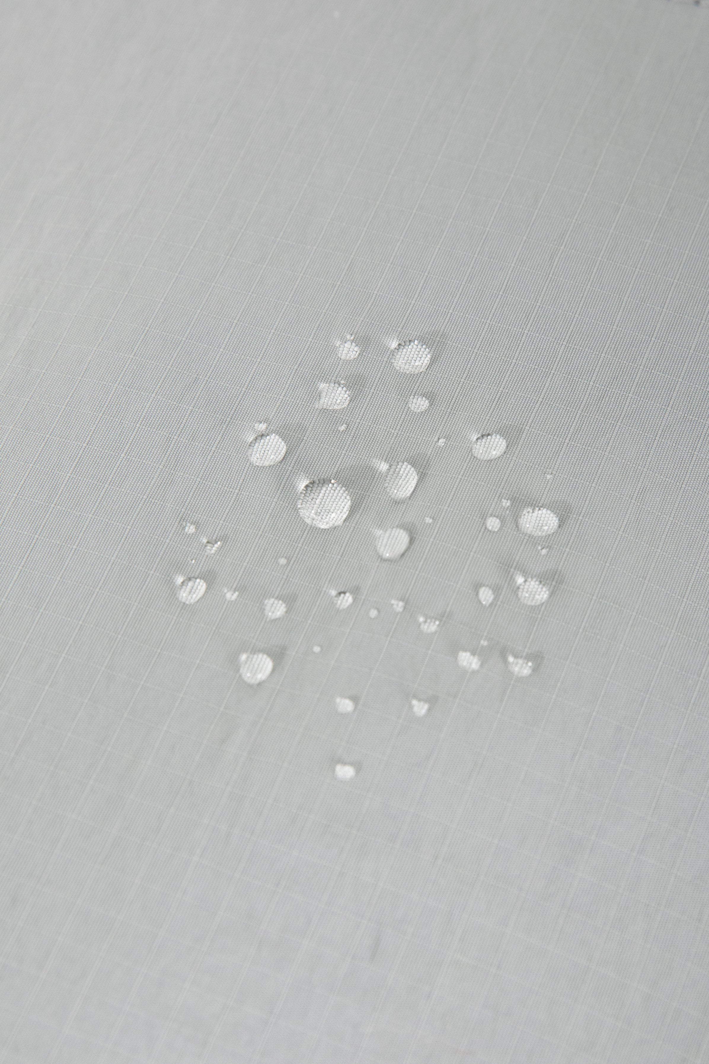 Water droplets on waterproof fabric of HiDREAM Crossbody Pet Carrier Tote. Durable and weather-resistant for outdoor use.