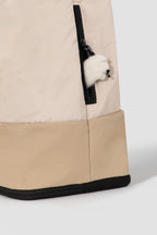 Close-up of side zipper pocket on beige HiDREAM Crossbody Travel Bag for Pets, partially open with plush toy inside.