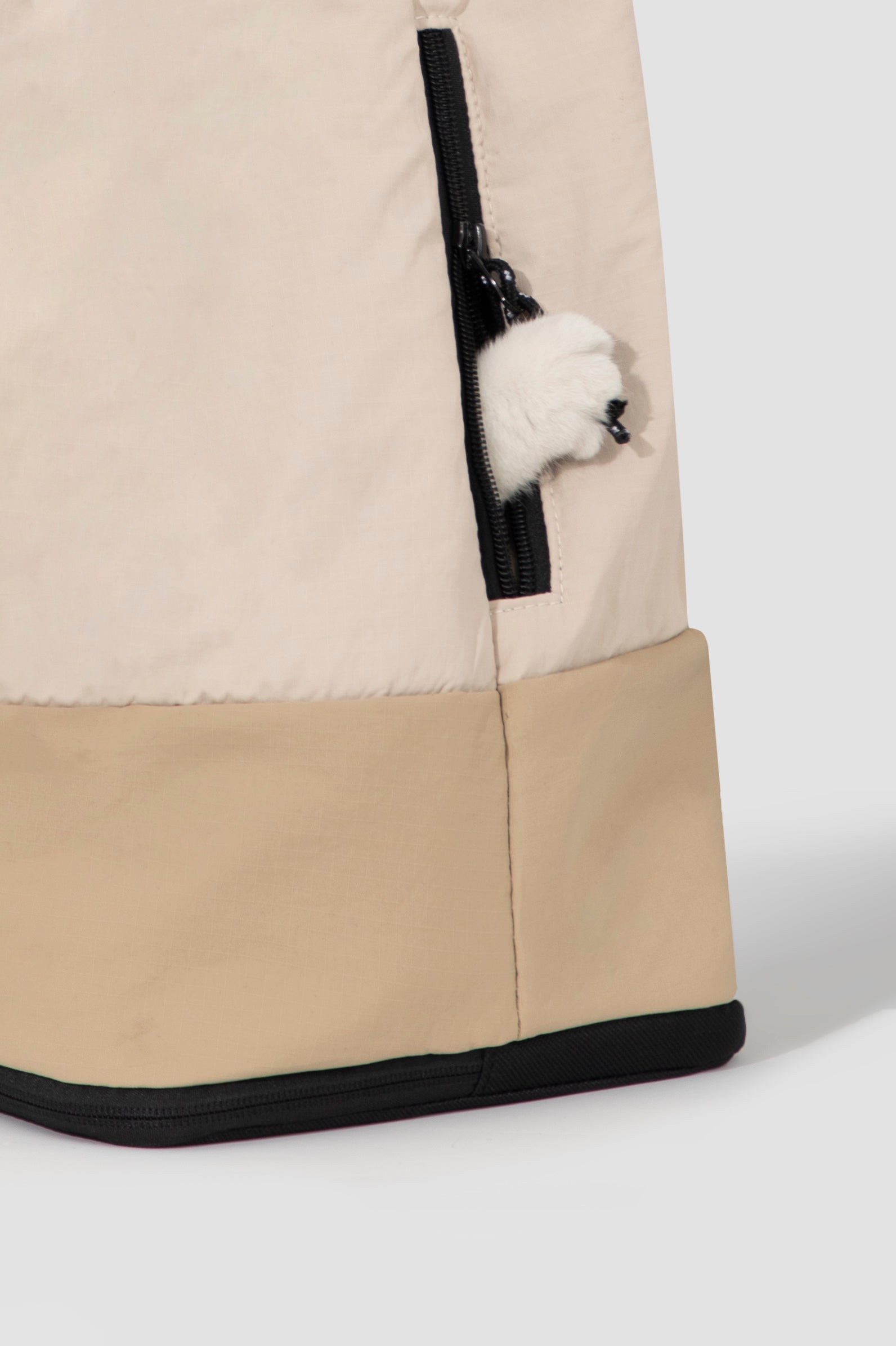 Close-up of side zipper pocket on beige HiDREAM Crossbody Travel Bag for Pets, partially open with plush toy inside.
