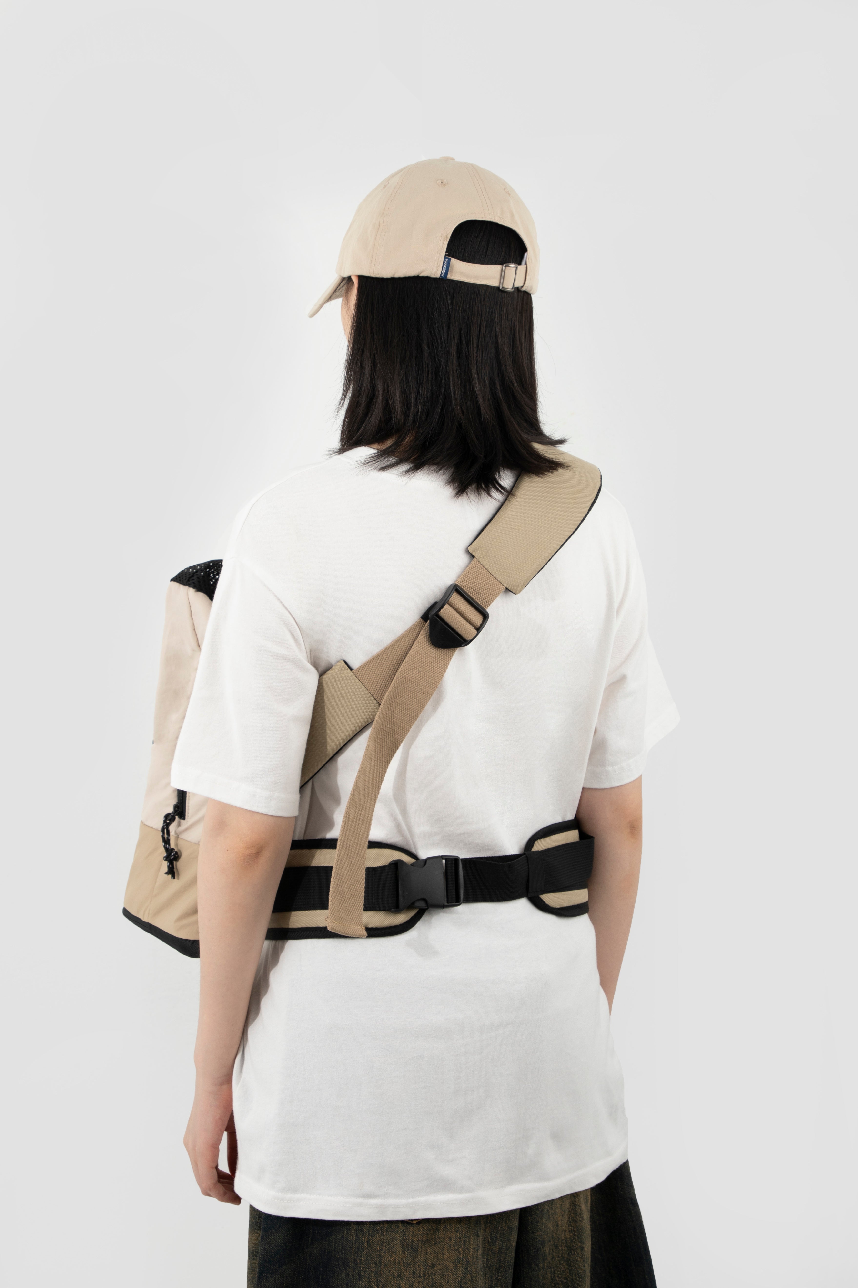 Back view of woman wearing beige HiDREAM Crossbody Travel Bag for Pets, showing adjustable strap and waist support.