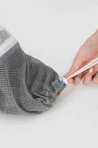 HiDREAM Cat Bathing Bag foot opening being tightened, showing adjustable mesh for safe paw access.