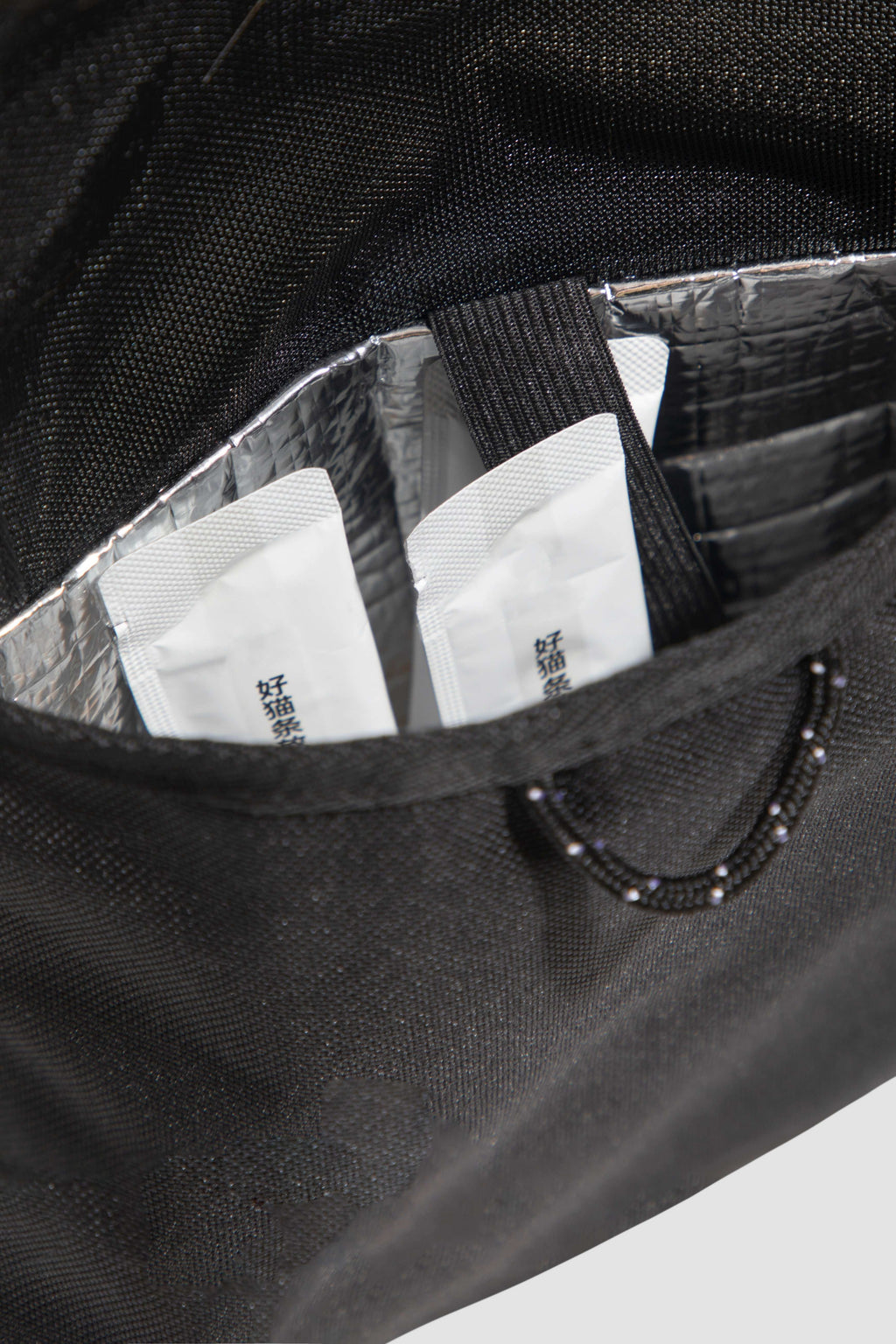 Insulated pocket inside HiDREAM Sling Pet Carrier holding pet treats. A 3-in-1 stylish papoose bag for pet travel in Australia.
