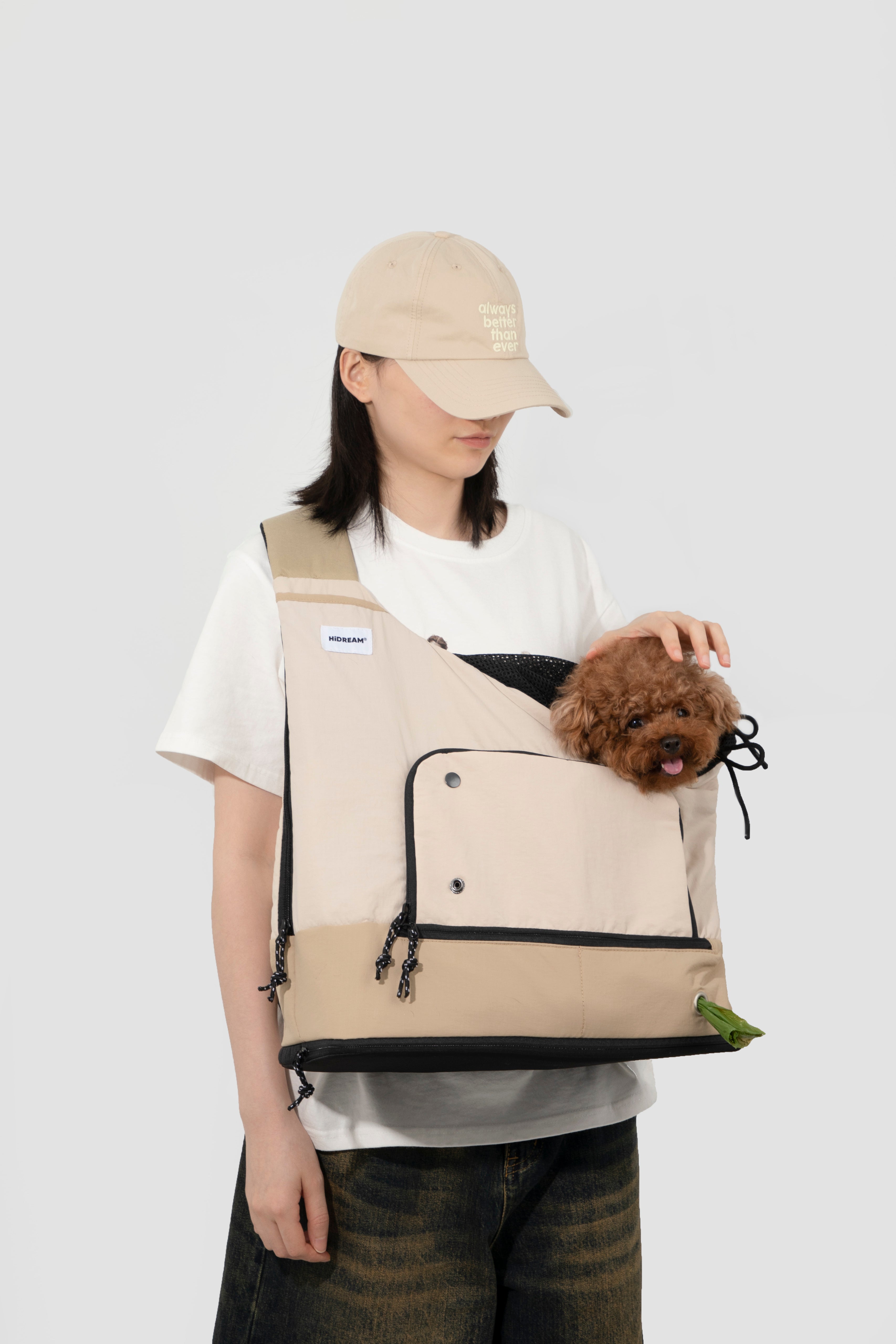 Woman placing a small dog into beige HiDREAM Crossbody Travel Bag for Pets, demonstrating secure and comfortable pet entry.