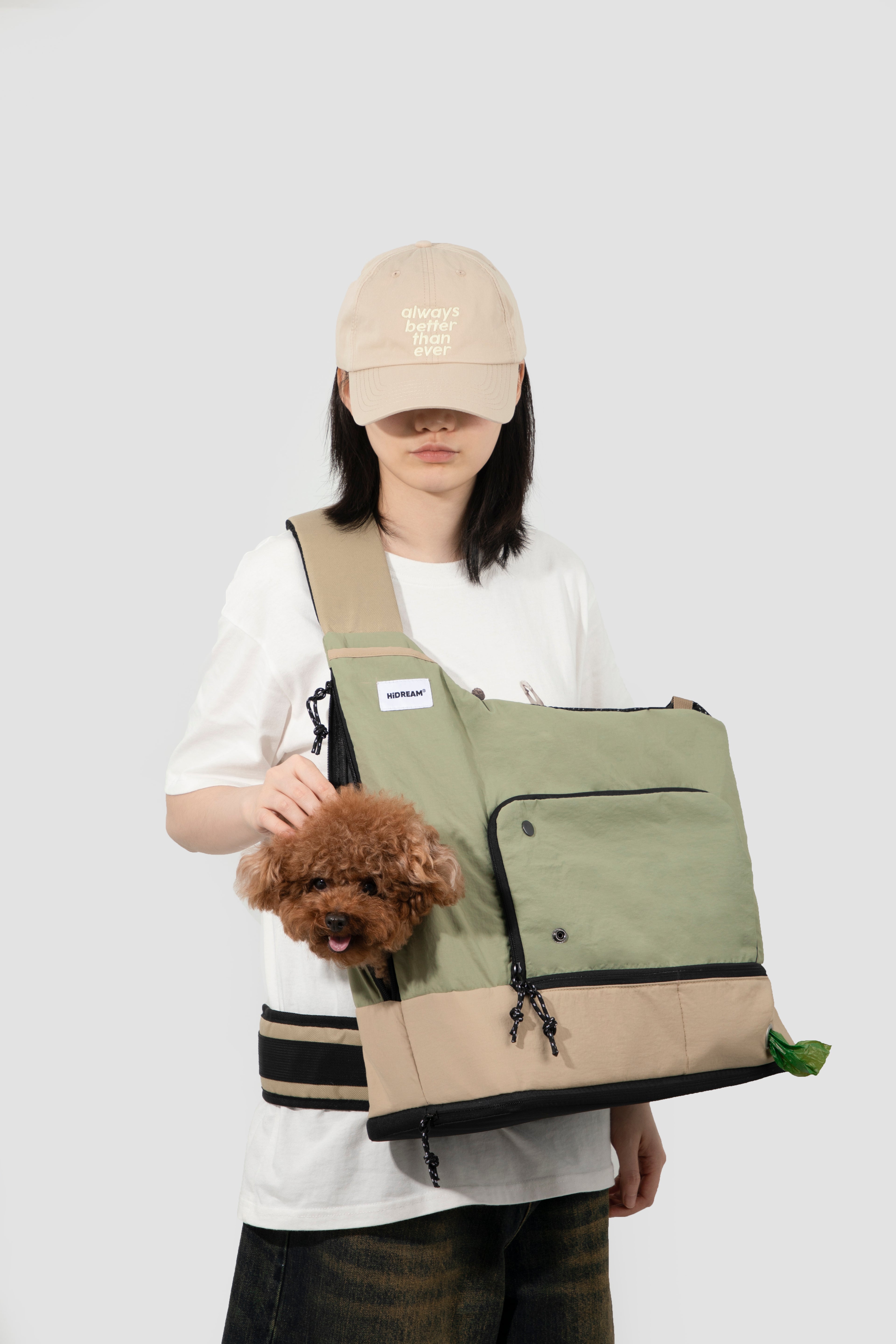 Woman holding a dog in green HiDREAM Crossbody Travel Bag for Pets, showing ergonomic strap and pet-friendly design.