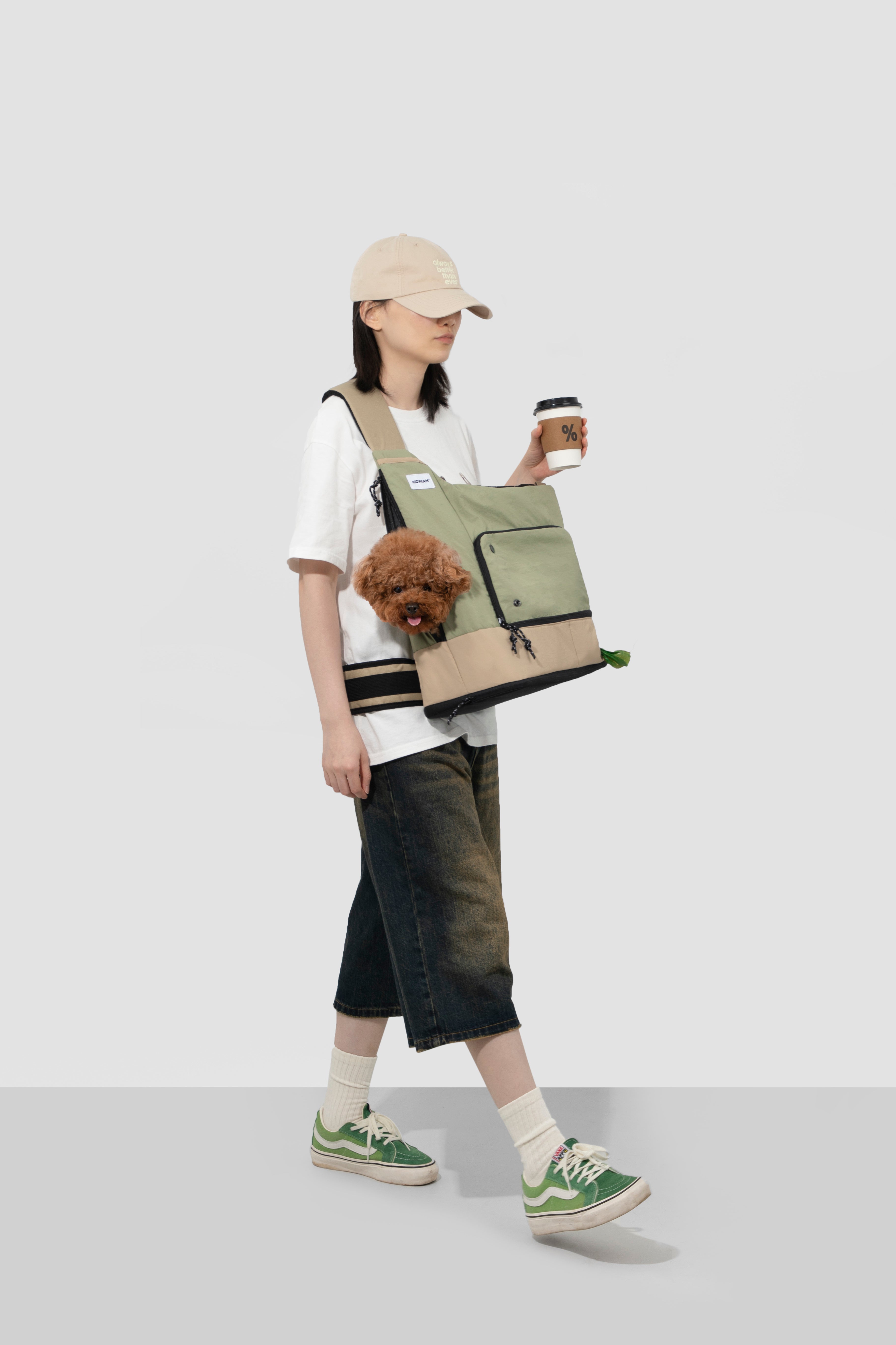 Side view of woman walking with green HiDREAM Crossbody Travel Bag for Pets, ergonomic strap and pet visibility emphasized.