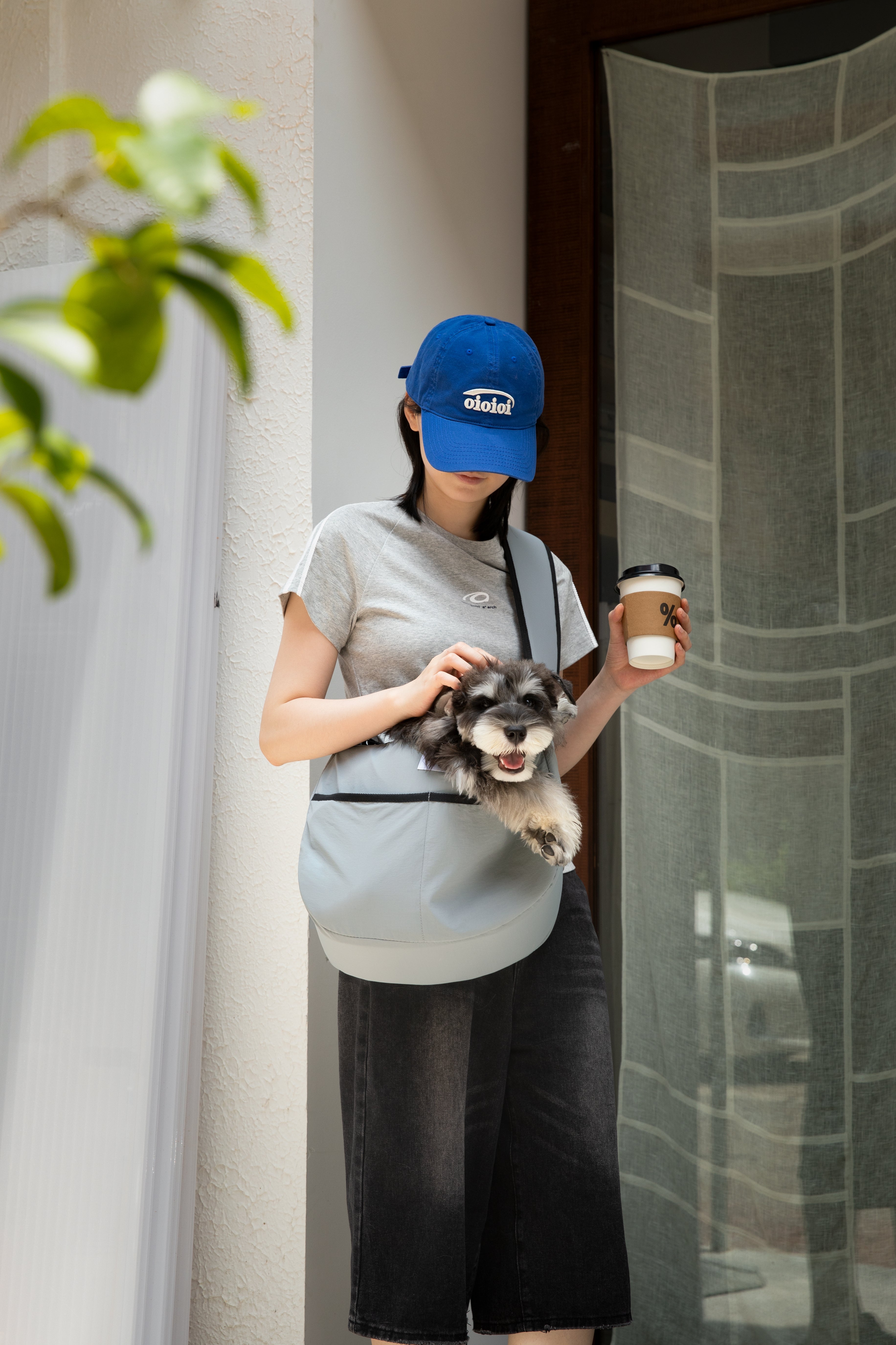Woman outdoors with dog in grey HiDREAM Crossbody Pet Carrier Tote. Ideal for travel, errands, and bonding with pets on the go.