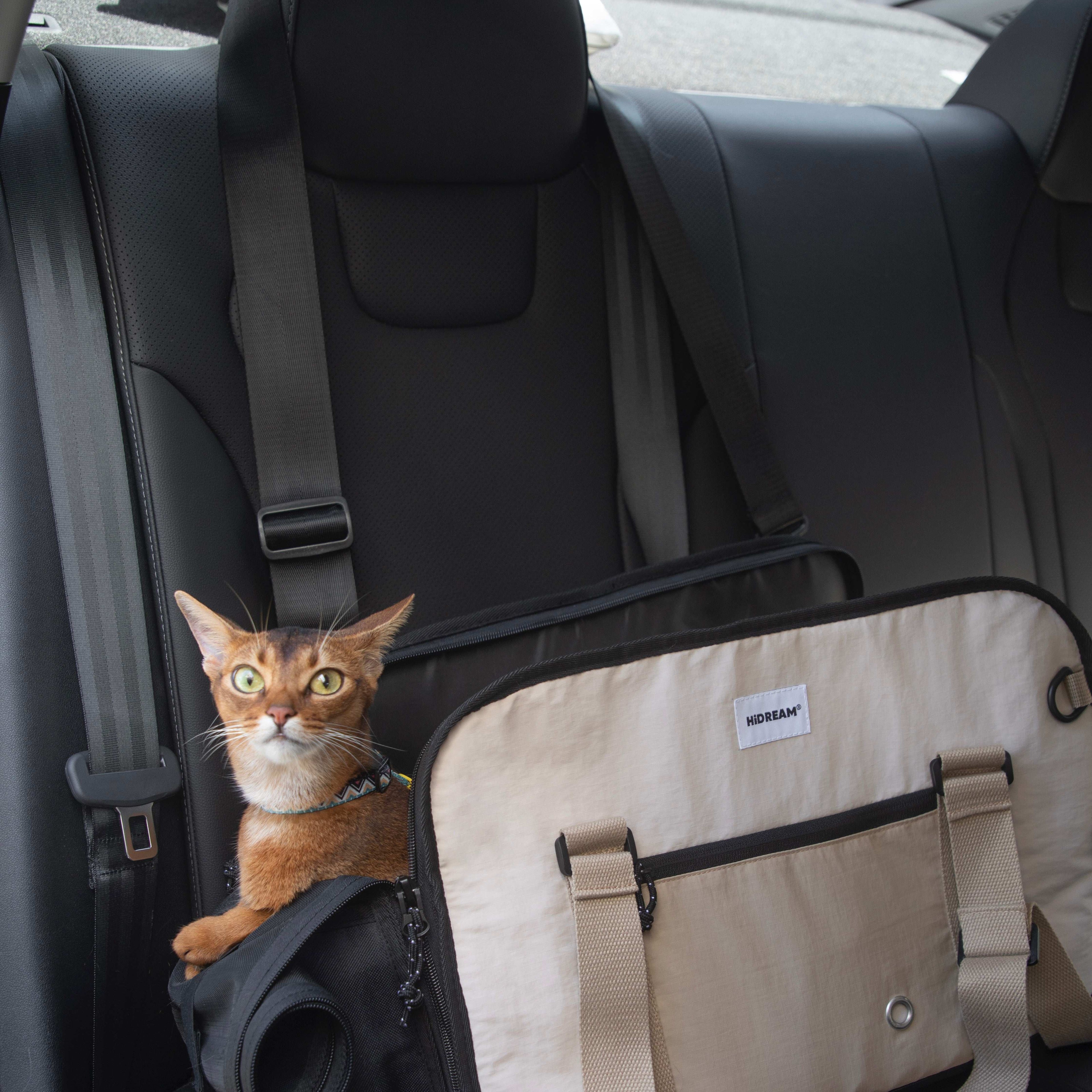 Cat sitting in HiDREAM Sling Pet Carrier on car seat. A 3-in-1 papoose bag for safe and stylish pet travel in Australia.