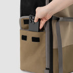 Close-up of HiDREAM Pet Car Seat Backpack – Dual Use Carrier’s side pocket with a phone being stored, showing added storage functionality.
