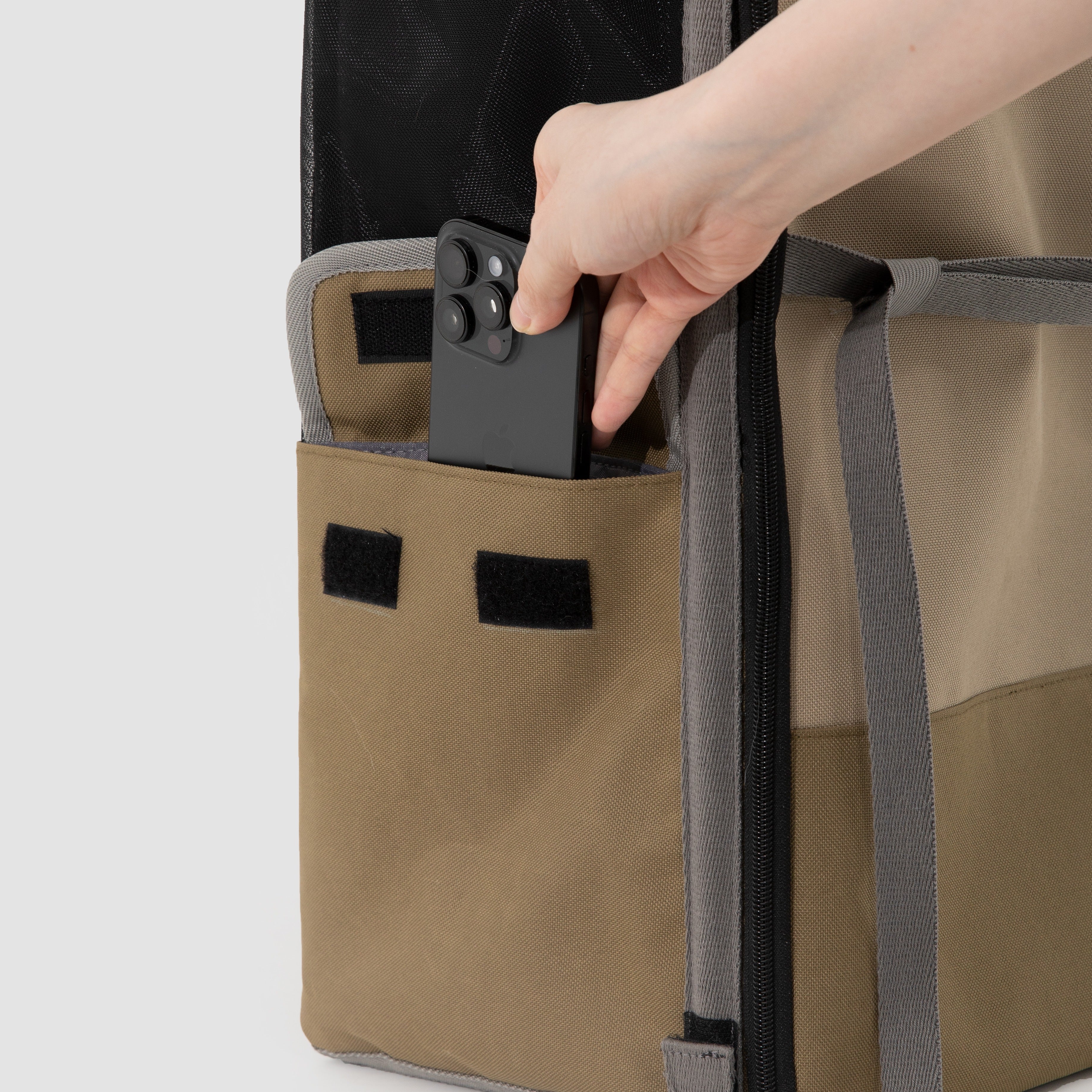Close-up of HiDREAM Pet Car Seat Backpack – Dual Use Carrier’s side pocket with a phone being stored, showing added storage functionality.