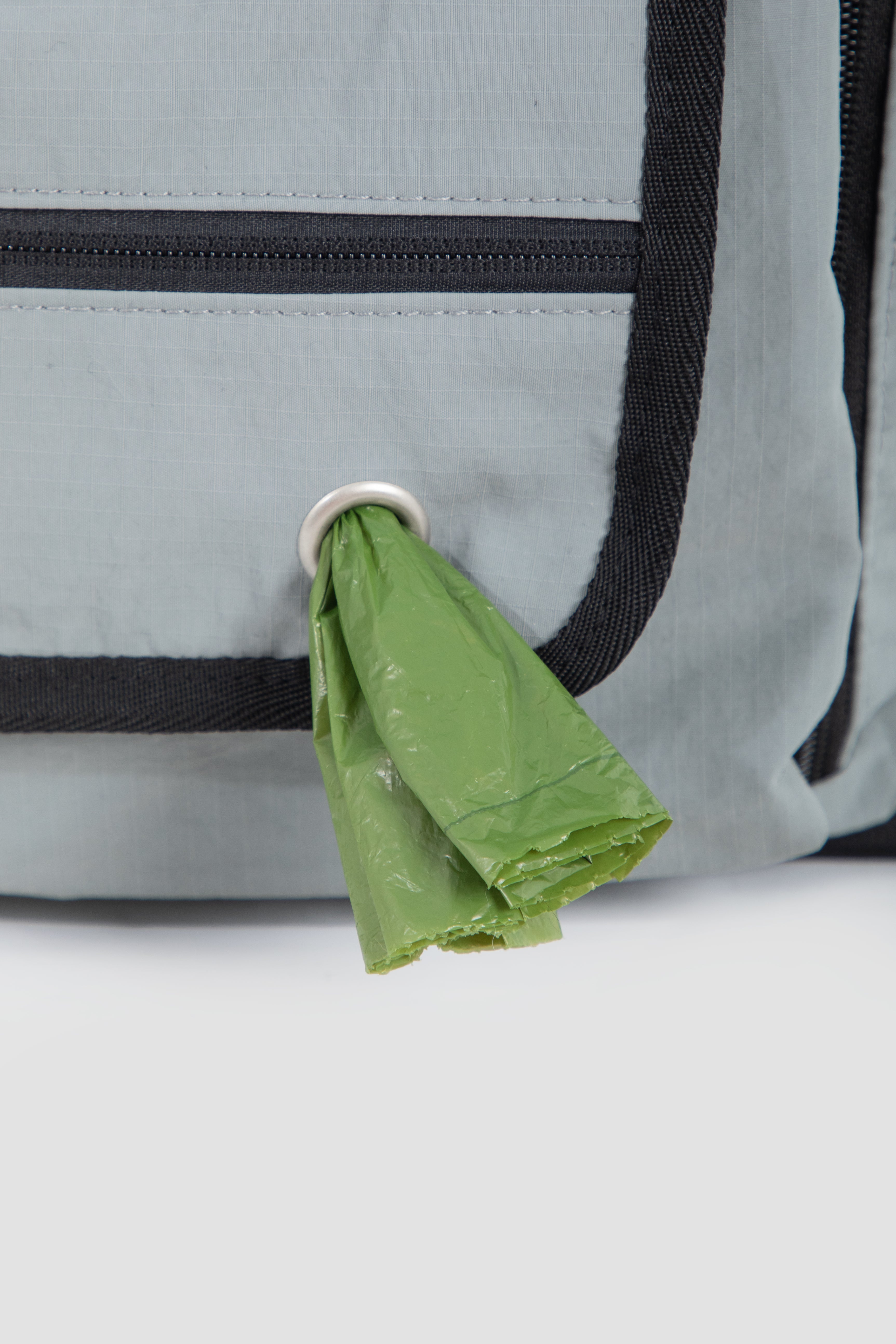 Built-in poop bag dispenser on HiDREAM Mountain Series Chest Pet Tote front pocket for convenient pet waste management.