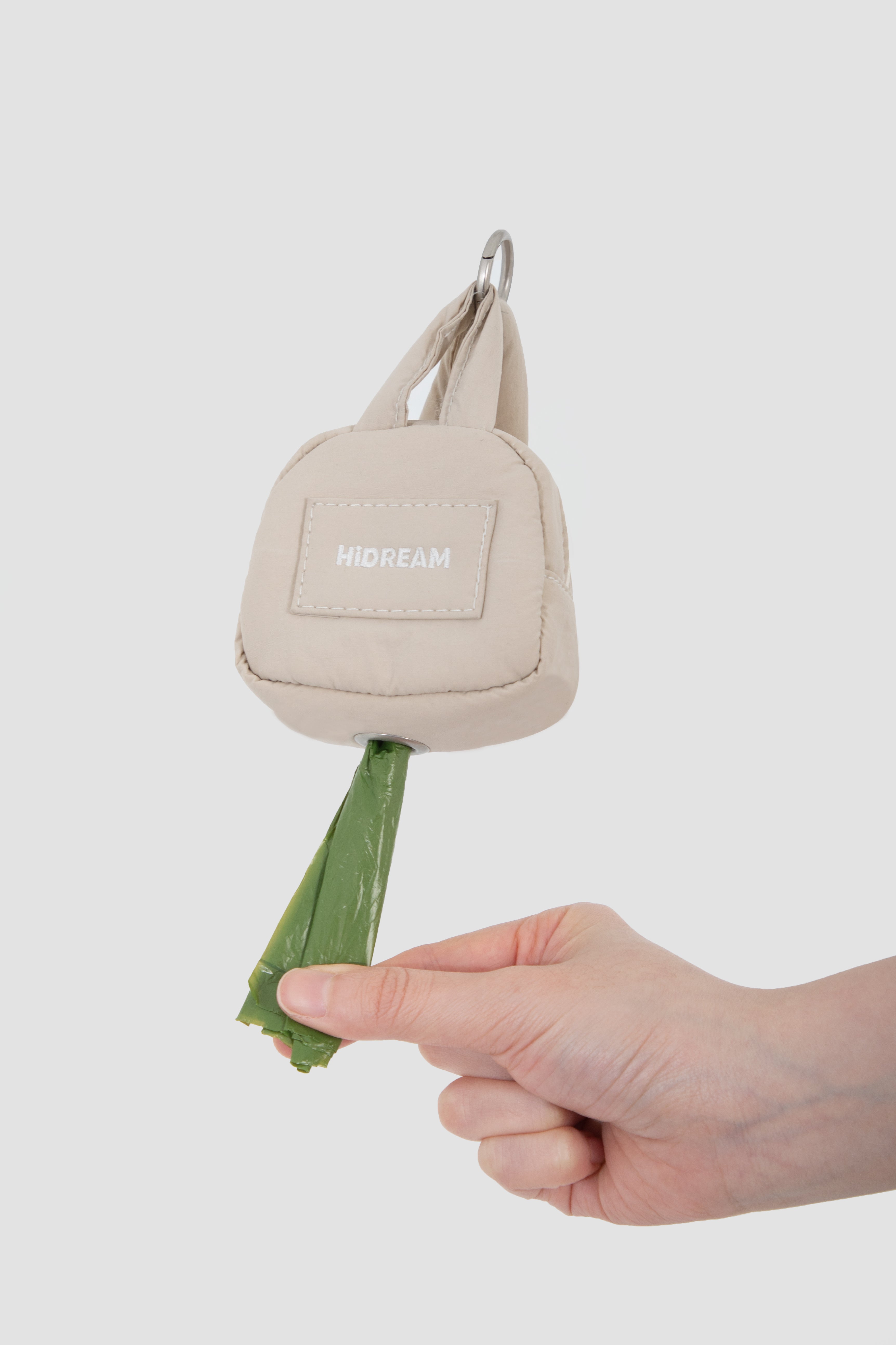 Hand pulling poop bag from HiDREAM Dog Poop Bag Holder, showcasing quick-draw front for mess-free access.