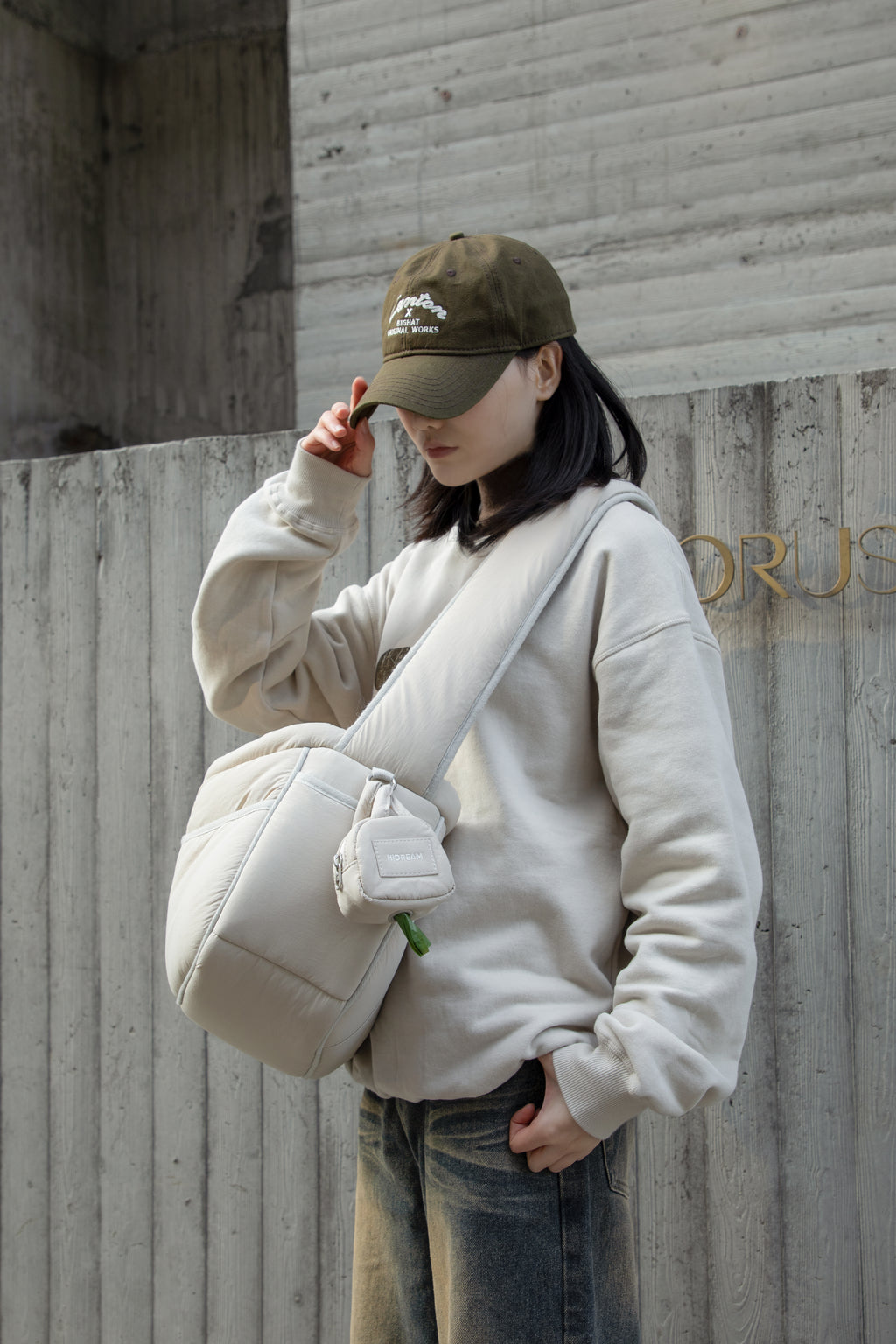 HiDREAM Dog Poop Bag Holder clipped to crossbody bag outdoors, blending fashion and function for pet owners.