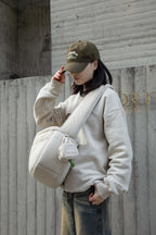 HiDREAM Dog Poop Bag Holder clipped to crossbody bag outdoors, blending fashion and function for pet owners.