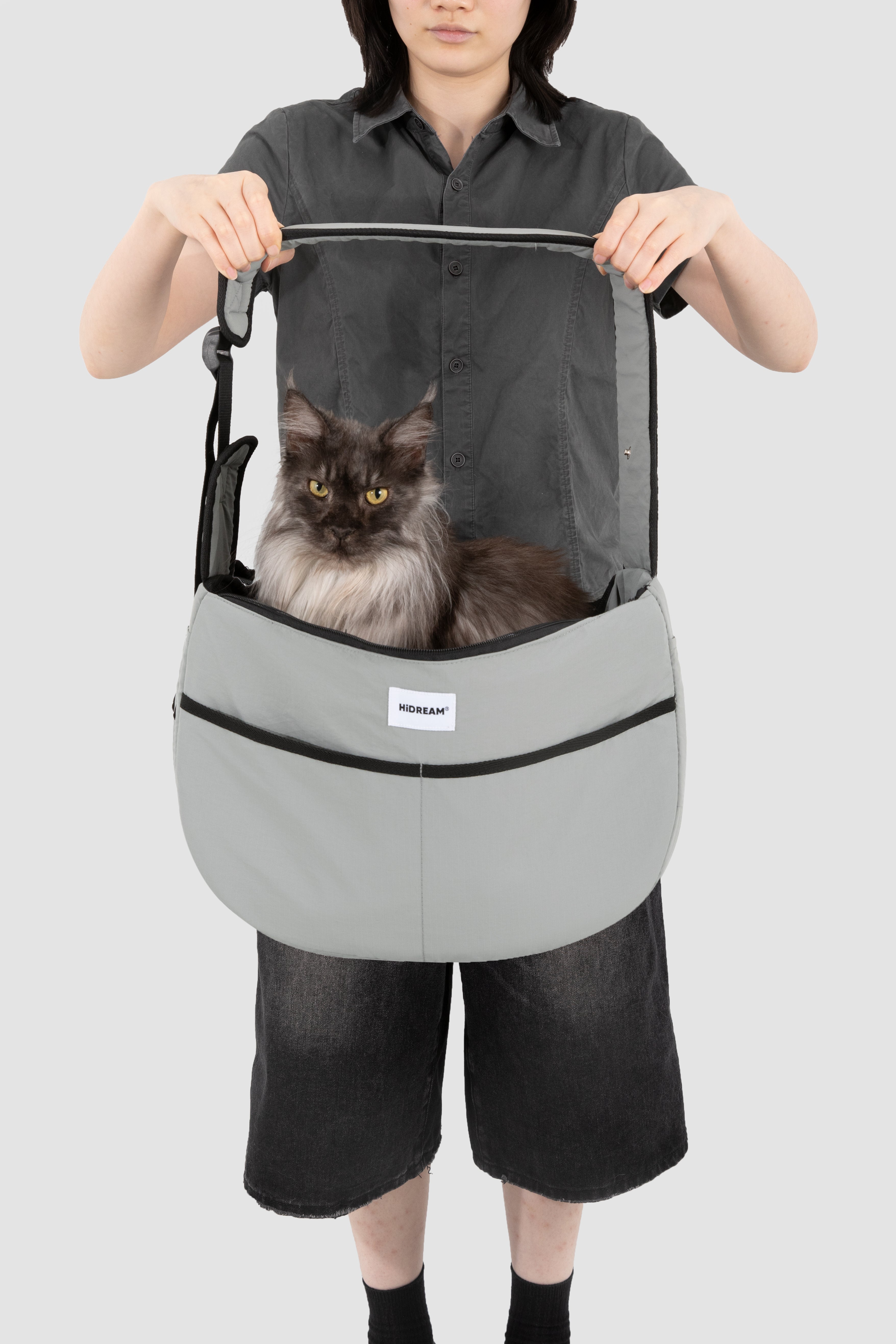 Large grey HiDREAM Crossbody Pet Carrier Tote holding a long-haired cat. Spacious and ergonomic for pet comfort and owner convenience.