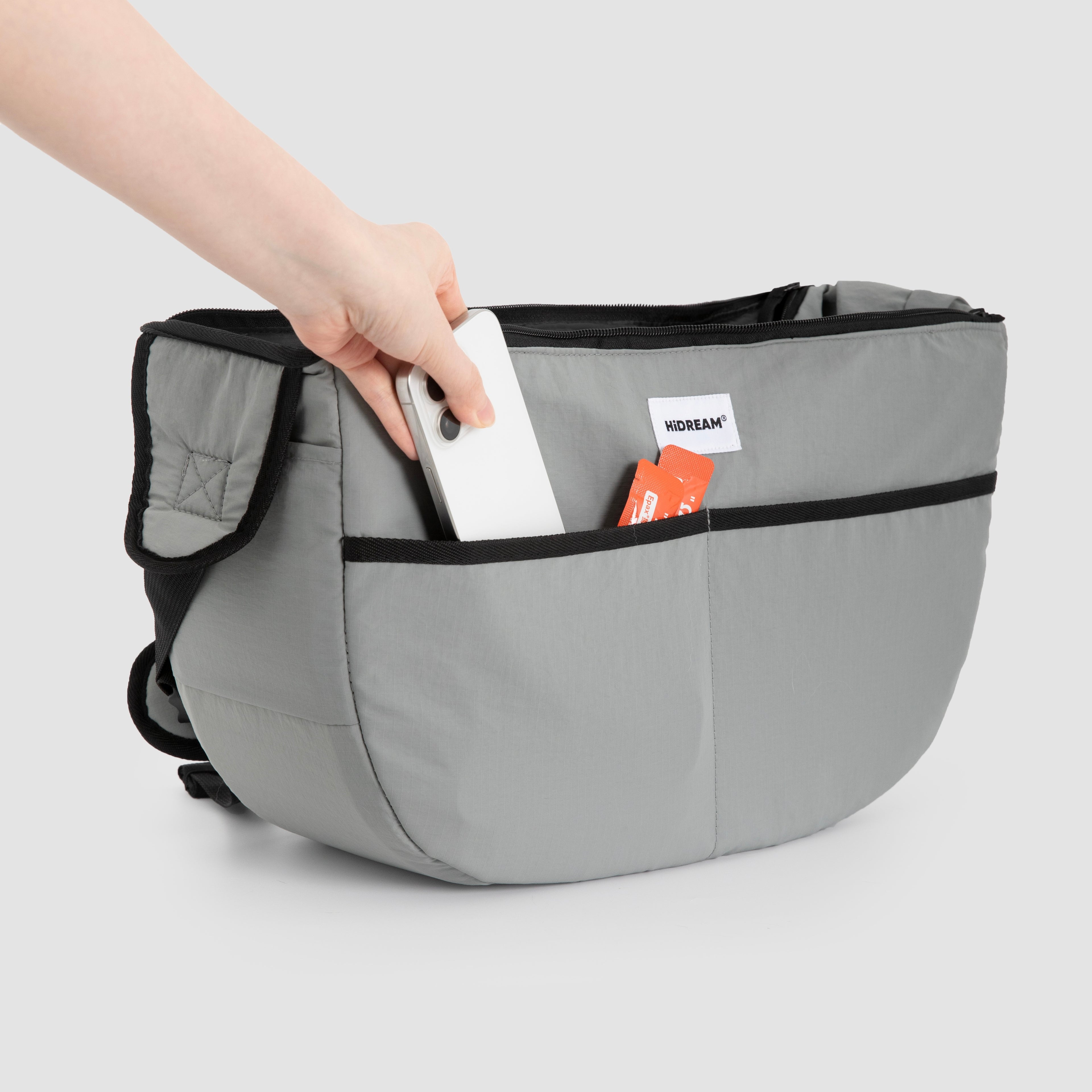 Grey HiDREAM Crossbody Pet Carrier Tote with phone and cards in front pocket. Convenient storage for essentials during pet outings.