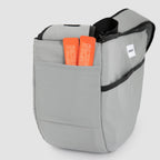 Side pocket of grey HiDREAM Crossbody Pet Carrier Tote holding pet accessories. Extra storage for treats, leashes, or documents.