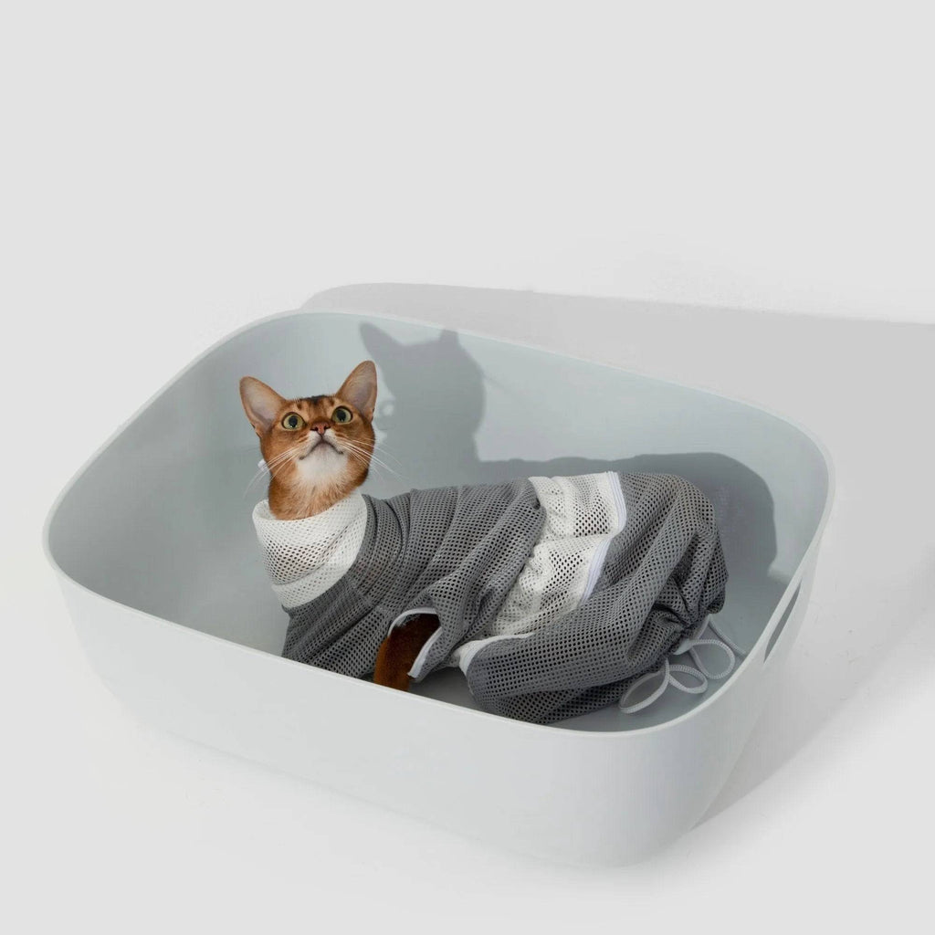 HiDREAM Cat Bathing Bag holding a cat in a white tub, showing secure and breathable mesh for calm grooming sessions.