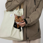 HiDREAM Padded Tote Bag in cream with a cat peeking from the side opening, highlighting its secure and cozy pet carrier features.