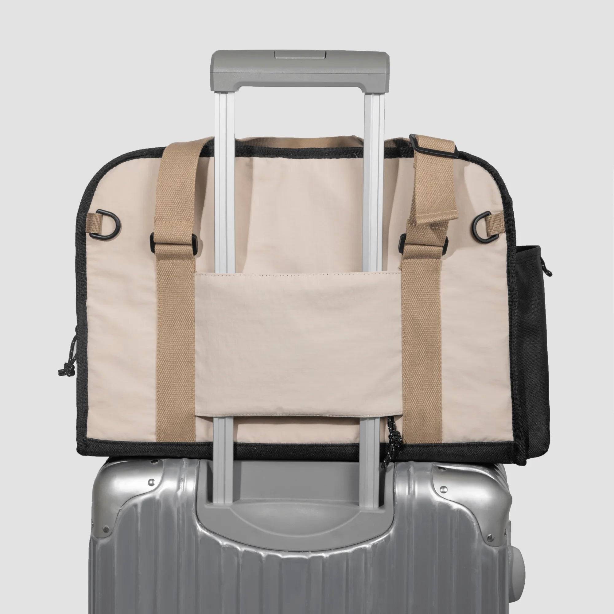 HiDREAM Sling Pet Carrier secured on suitcase handle. A 3-in-1 papoose bag designed for stylish and easy pet travel in Australia.